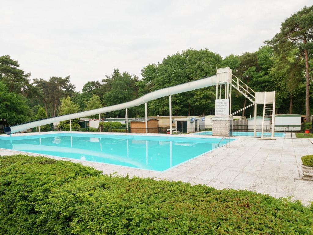 a swimming pool with a white bridge over it at Holiday Home in Arriën near Beerze Nature in Ommen
