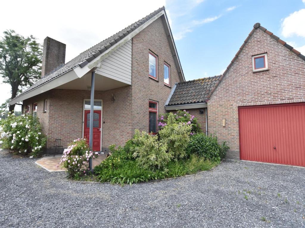 a brick house with a red garage at Holiday Home near Bruges and Cadzand in Eede