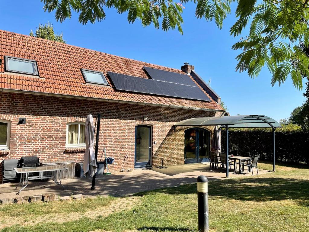 a house with a solar panel on the roof at Coachman's House near Roermond with Garden in Sint Odiliënberg