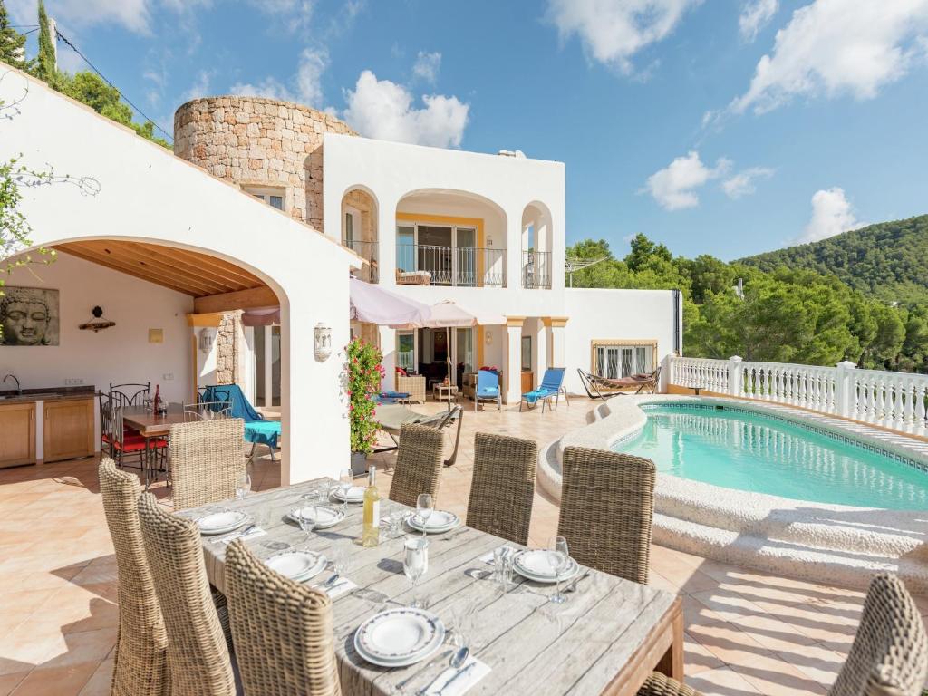 an external view of a villa with a table and a swimming pool at Villa in Cala Llonga near Beach & Ferry Port in Cala Llonga