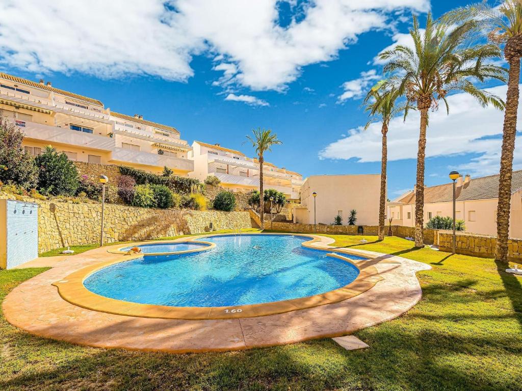 a swimming pool in a yard with palm trees at Bungalow Orihuela Costa Sunset and Pool in Relleu