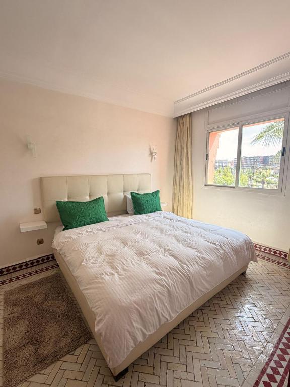 a bedroom with a large bed with two green pillows at إقامة أطلس جيليز in Oulad Akkou