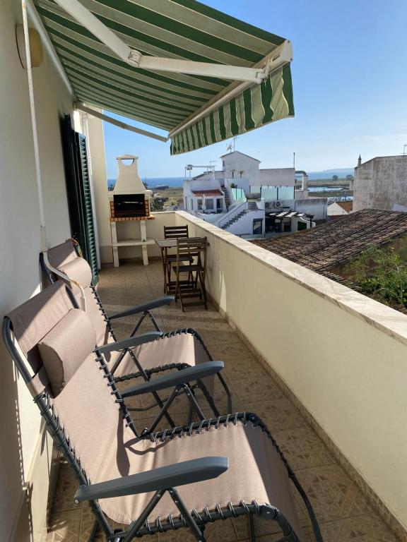 a balcony with chairs and a piano on a roof at Esteves Apartment - Alvor Center in Alvor