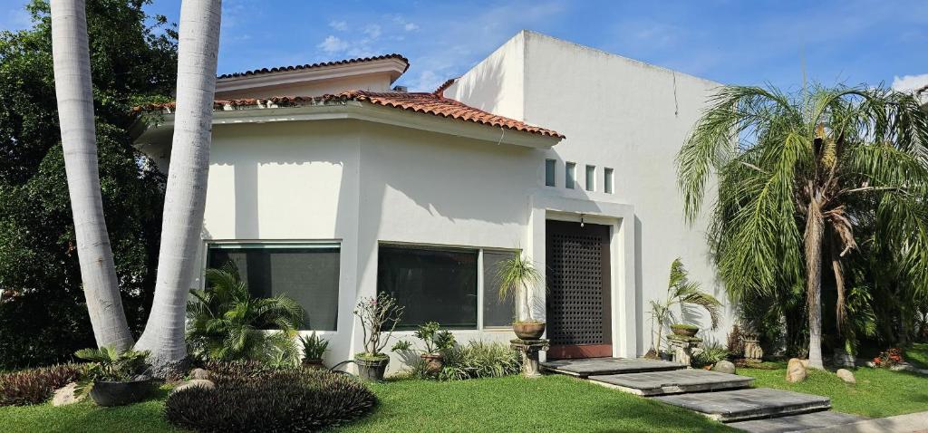 a white house with palm trees and a yard at Casa Velero in Puerto Vallarta