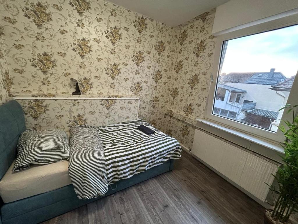 a small bedroom with a bed and a window at Wohngemeinschaft mit Privatzimmern in Niederdorla