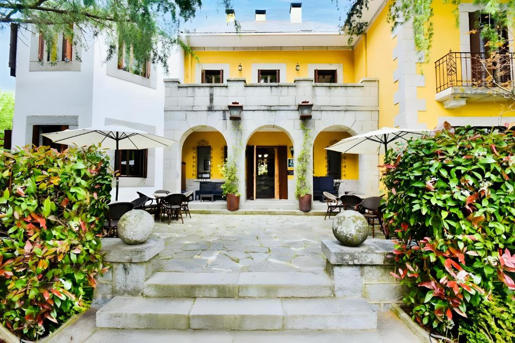 a courtyard of a building with chairs and umbrellas at Hotel Punta Me Torreblanca Palace in Guadarrama