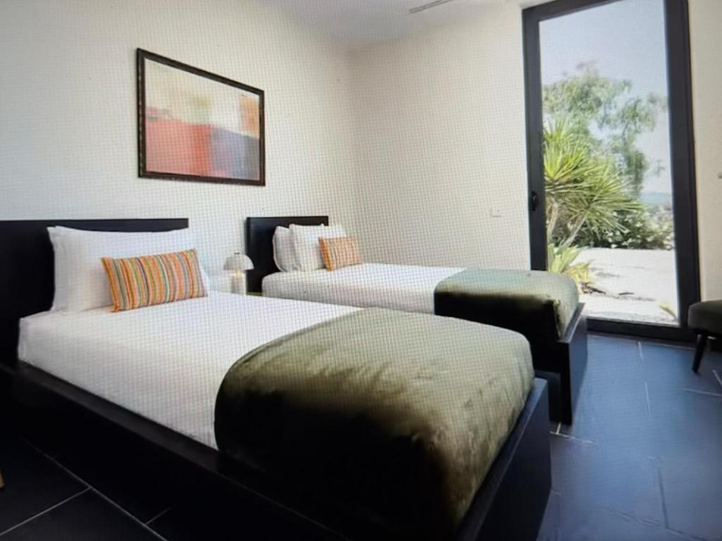 two beds in a room with a window at Exclusive Stunning Views Pool in Road Town