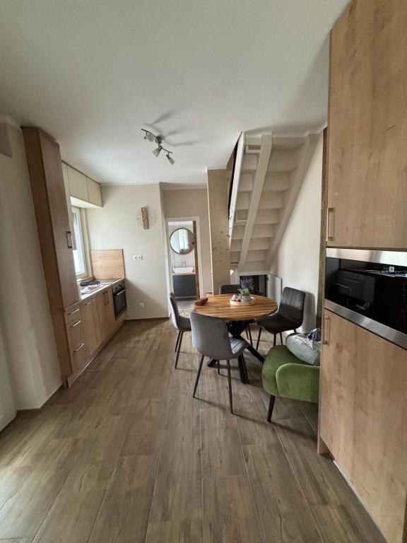 a kitchen and dining room with a table and chairs at JanBar Apartman in Bük