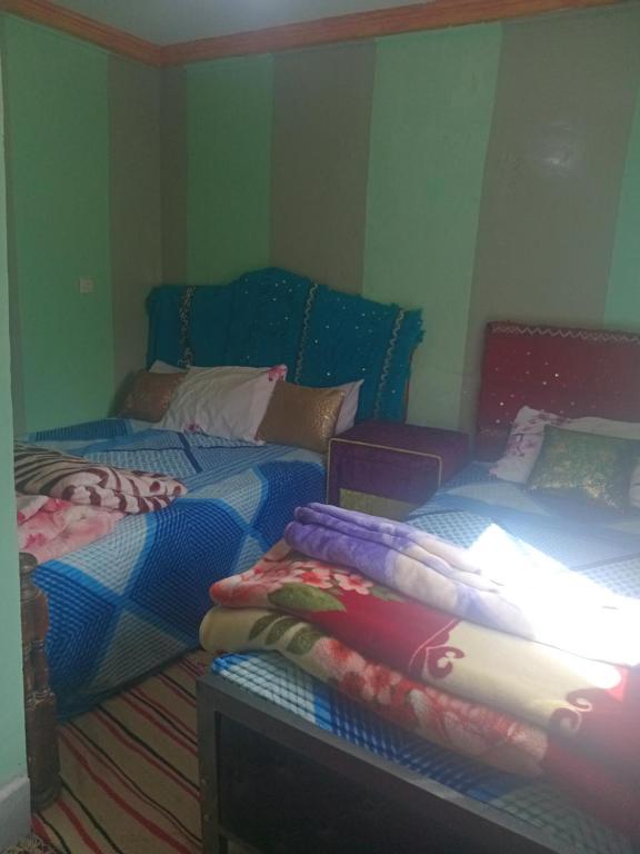 a room with two beds and a couch at Auberge High Atlas B&B in Alemrhou