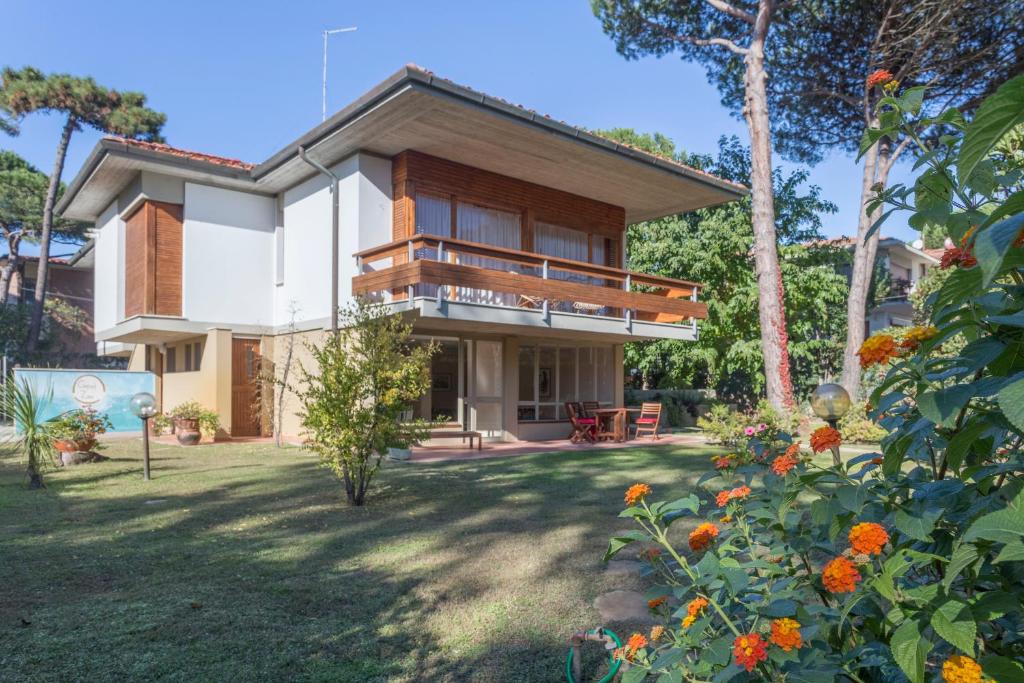 ein Haus mit einem Balkon und einem Garten mit Blumen in der Unterkunft Comfort Zone in Tirrenia