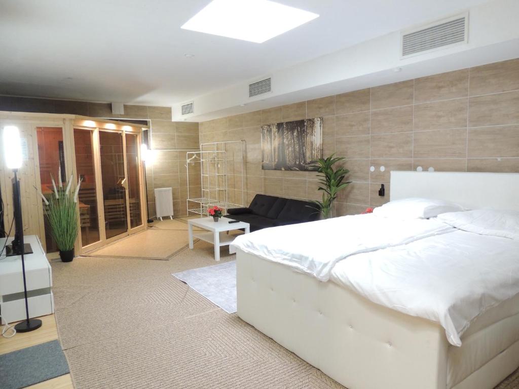 a bedroom with a white bed and a living room at Siggis und Anyas Ferienwohnung mit Sauna und XXXL-Dusche in Sasbachwalden