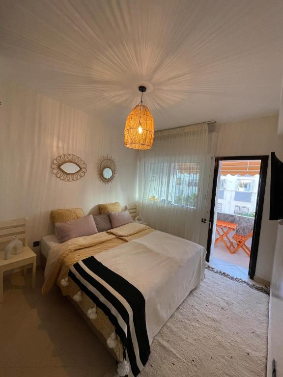 a bedroom with a large bed and a chandelier at Cozy Beachfront 2BR in Rabat - Central & Secure in Rabat