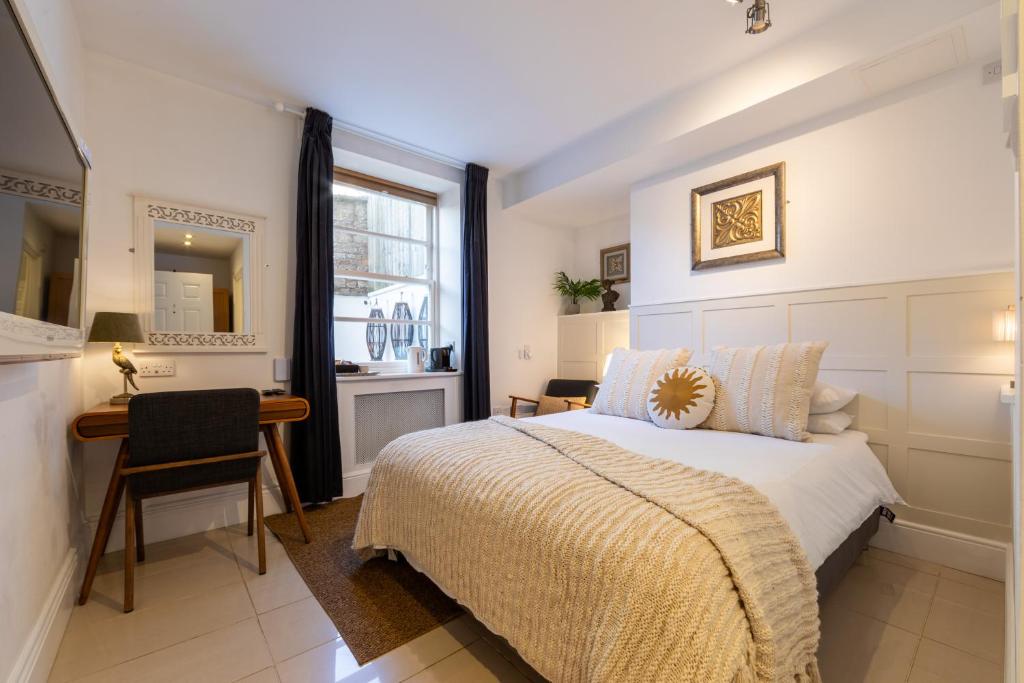 a bedroom with a bed and a desk and a window at Ferndale Mews in Bristol