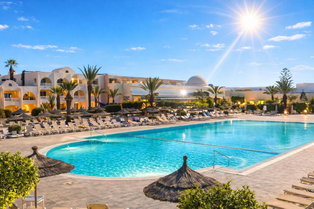 a pool with chairs and umbrellas at a resort at Djerba Aqua Resort in Midoun