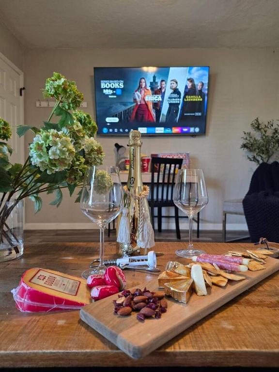 a wooden table with wine glasses and cheese and crackers at Brand new everything! Adjustable beds! Best House in Lawton