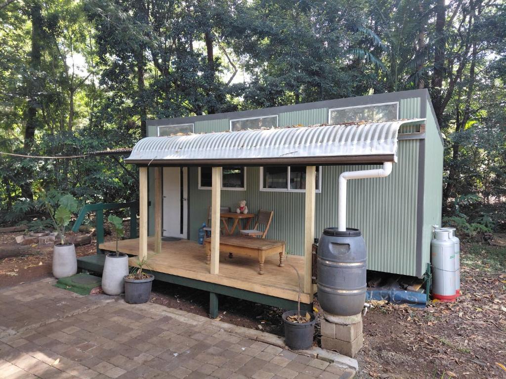 a small green house with a picnic table in it at Forest Gypsy Tiny Home in Barkers Vale