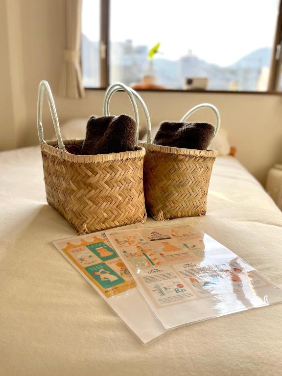 two baskets sitting on a table with a magazine at 眠りの癒201 I Cozy Apt, 3min Beach, Bus, Train, Onsen, Izakaya, WiFi in Beppu