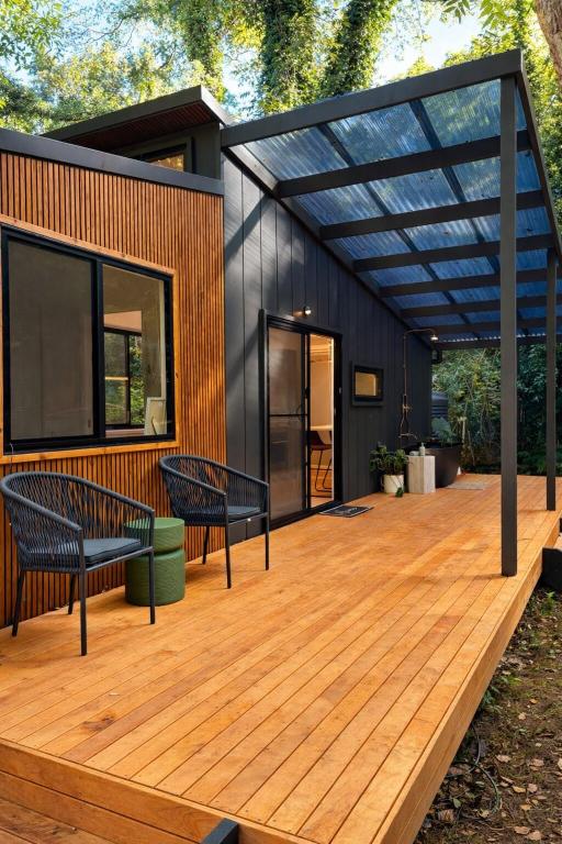 a house with a wooden deck with two benches at Wave and Willow Tiny Home in Broughton Village
