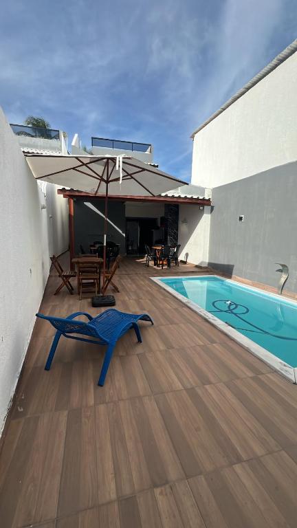 a patio with a pool and a table and an umbrella at Temporadaemjaua in Camaçari