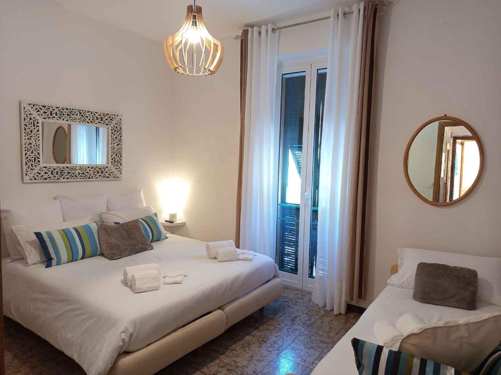 a bedroom with two beds and a mirror and a window at La Yucca in Dolceacqua