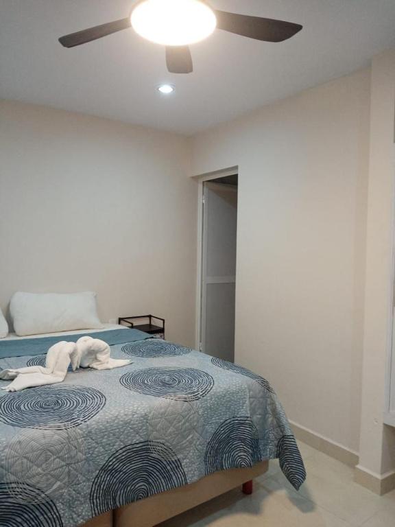 a white dog laying on a bed in a bedroom at Hermoso apartamento nuevo in Isla Mujeres
