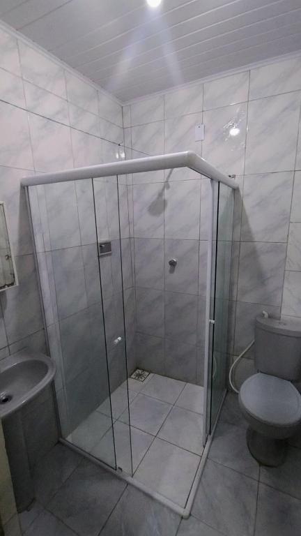 a bathroom with a shower and a toilet at Oliveira Hospedagens in Salvador