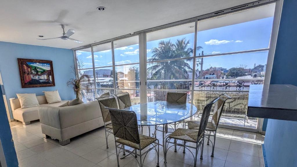 a dining room with a glass table and chairs at Henrietta Place B&B in Progreso