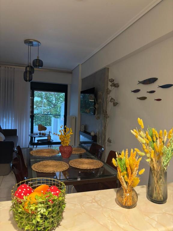 a living room with a table and vases with flowers at The cozy seaside apartment in Nafpaktos