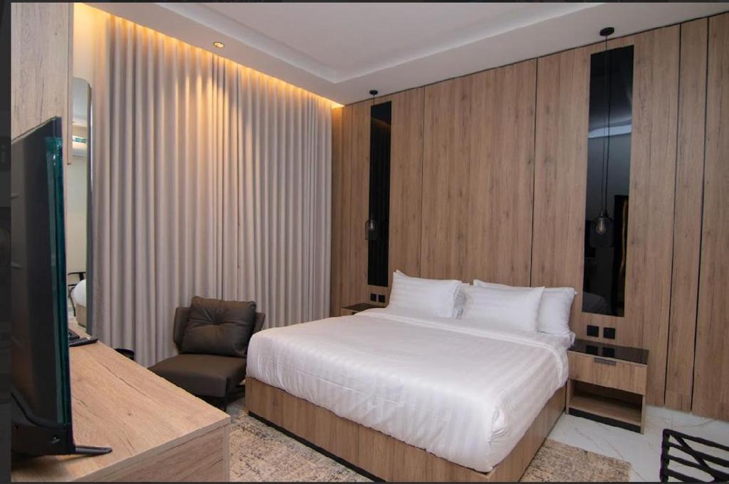 a bedroom with a white bed and a chair at Princess House in Jeddah