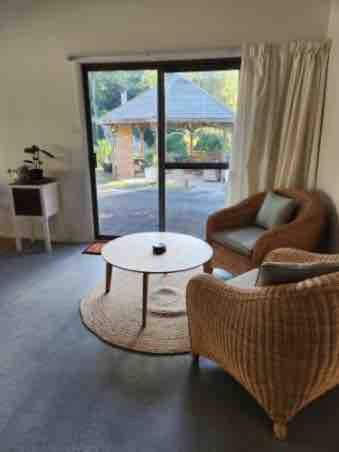 a living room with a couch and a table and a chair at Friends With Bienefelts in Turners Beach