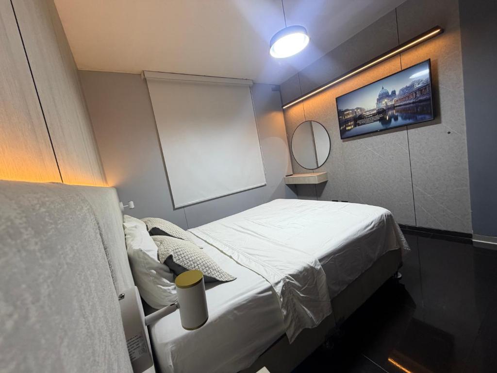 a small room with a bed and a mirror at Miraflores Alcanfores in Lima