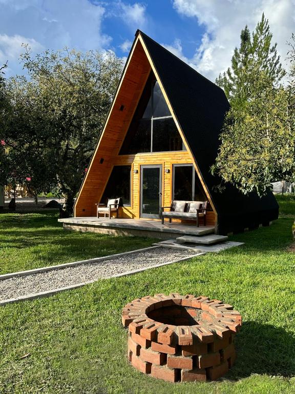 a small house with a brick fire pit in the grass at Villa Alpina in Oxapampa