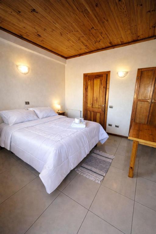 a bedroom with a large white bed with a wooden ceiling at Hotel Italia in Ovalle