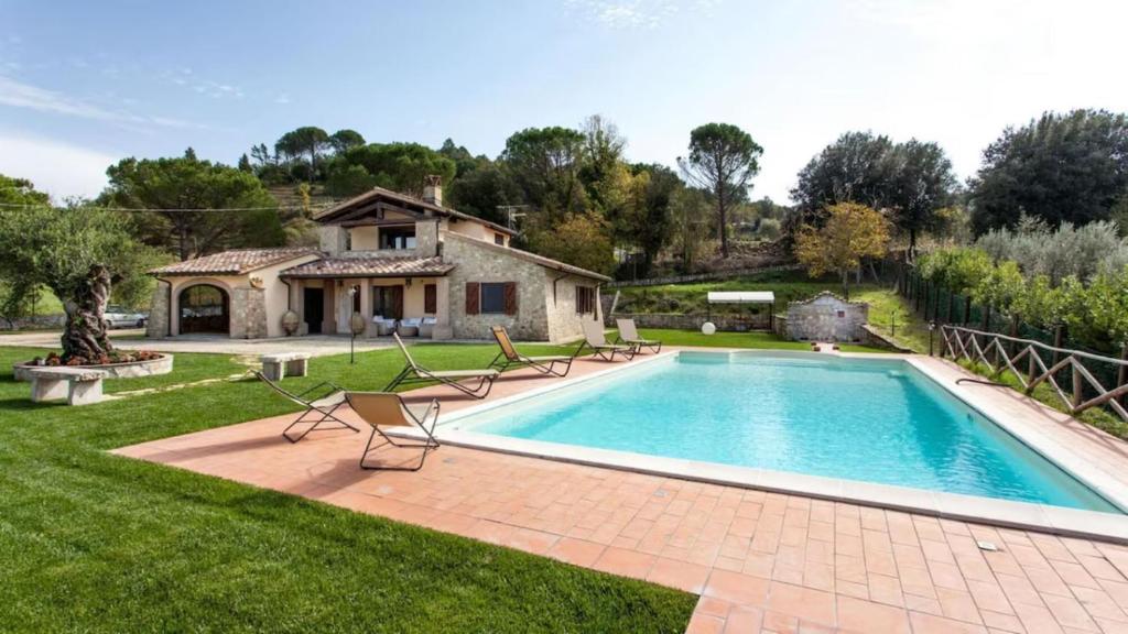 a swimming pool in a yard with a house at Umbria Genius Loci Farmhouse in Gaglietole