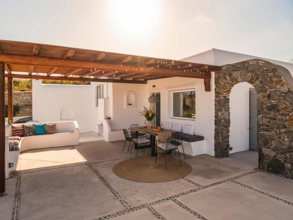 a living room with a table and a stone wall at Kalafatis Stay with Private Pool in Kalafatis