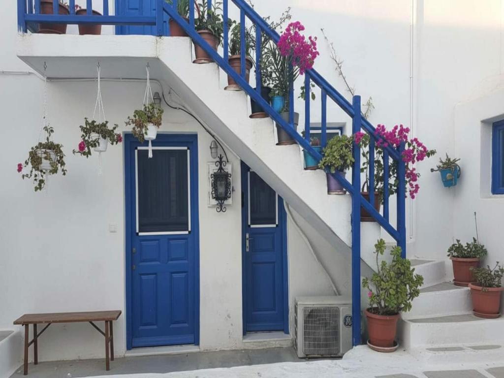 a blue door and stairs with potted plants at Mykonos Town Home for Two in Megali Ammos