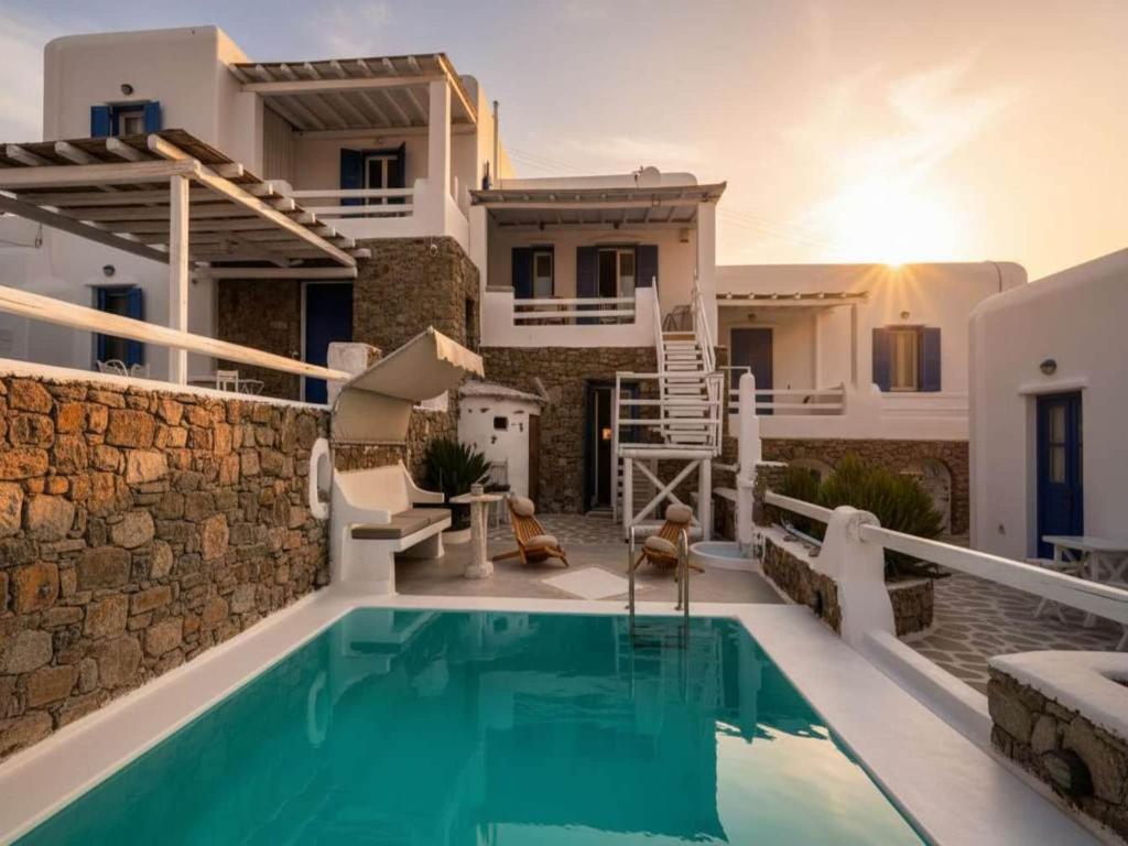 a villa with a swimming pool in front of a house at Panormos Retreat with Pool in Mikonos