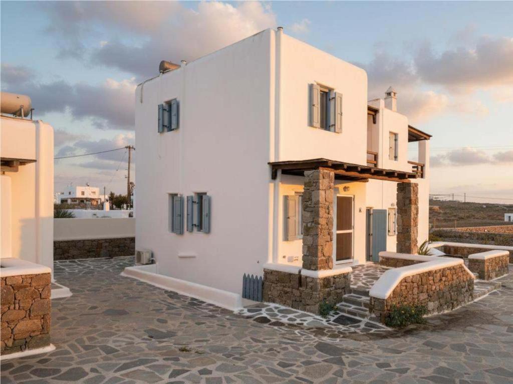 a house with white walls and windows on a street at 3-Bed Home in Ano Mera in Ano Mera