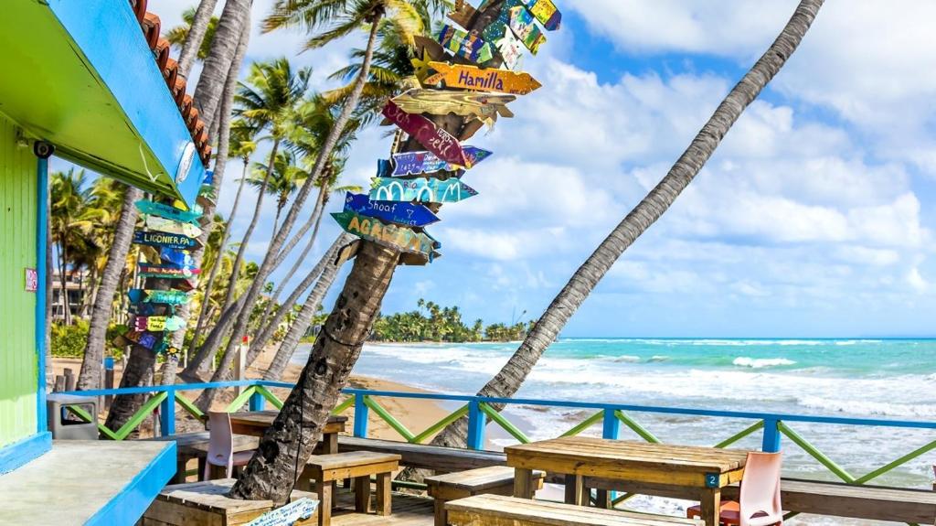 a restaurant on the beach with palm trees at Solimar Villa Family Vacation Spot in Playa de Guayanes
