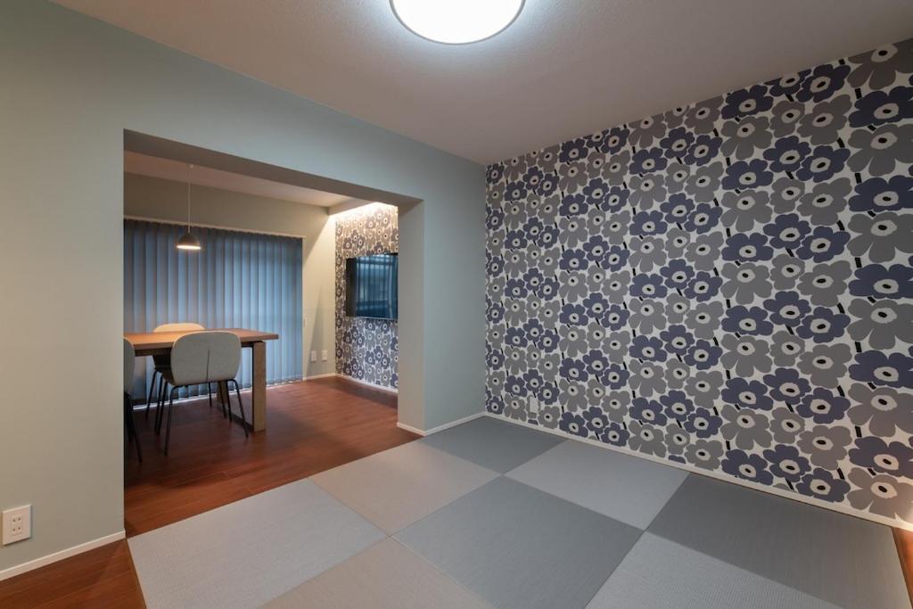 a dining room and living room with a patterned wall at PaPa's Resort 那須 in Nasushiobara