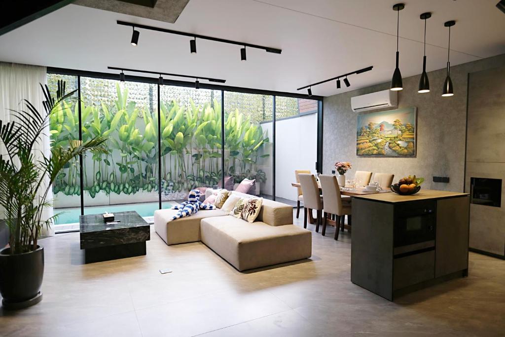 a living room with a couch and a table at SWOI LOFT UMALAs Designer 2BR Private Pool Villa in Kerobokan