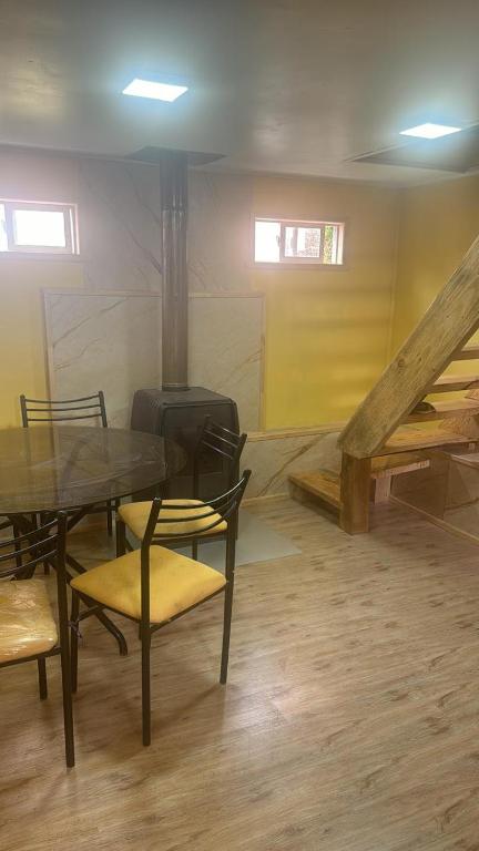 a room with a table and chairs and a staircase at Lenayu in Pudeto