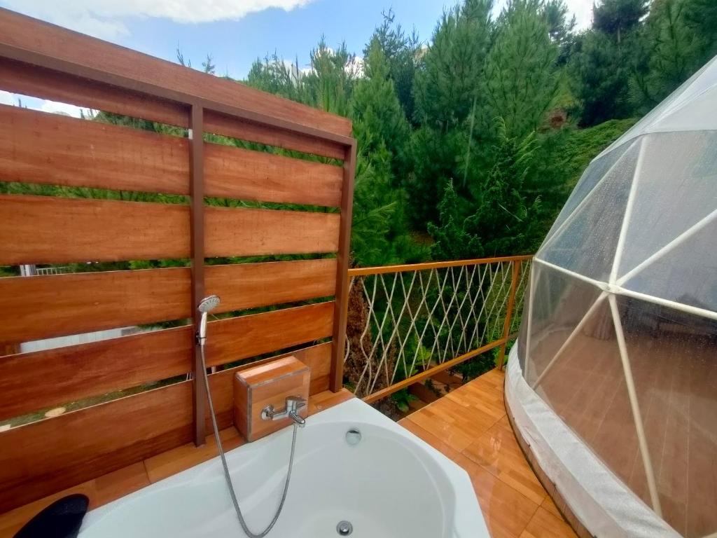 a bathroom with a bath tub on a balcony at Glamping Dome Kusumanagara 2 in Bandung