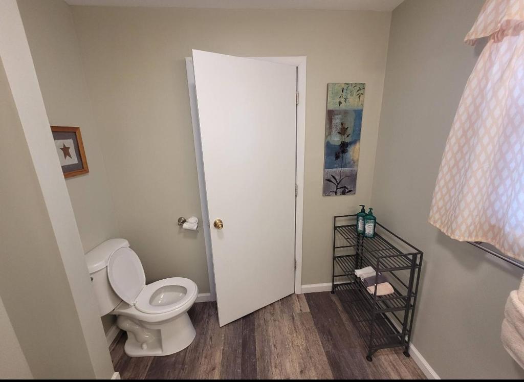 a bathroom with a white toilet and a door at Bay Front Manor House in Deale