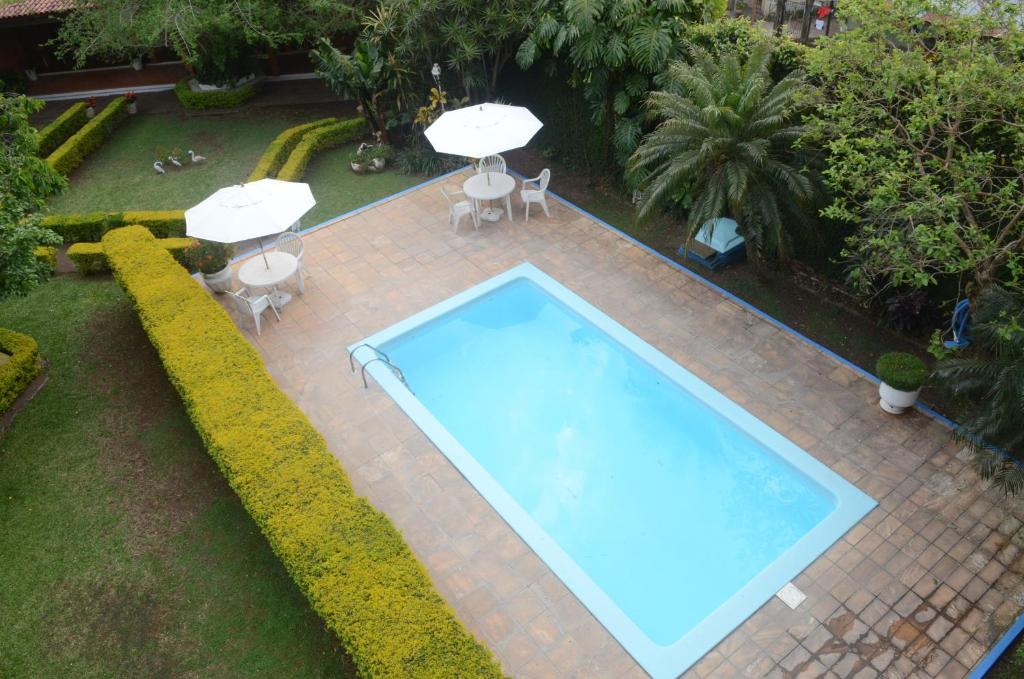 una vista dall'alto di una piscina con sedie e ombrelloni di River Hotel a Uruguaiana