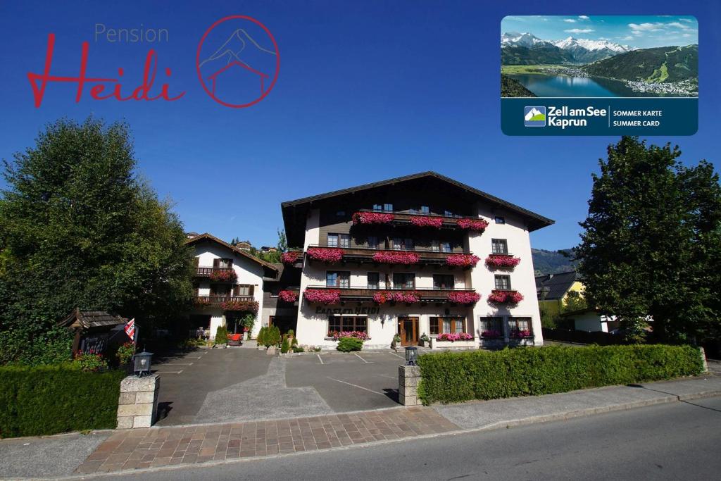 a building with red flowers on the balconies on it at Pension Heidi in Kaprun