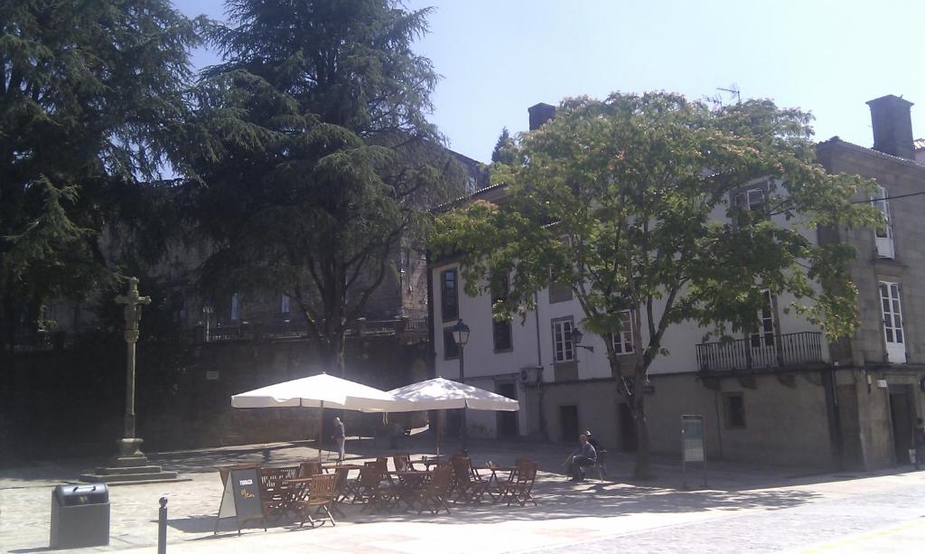 a table with an umbrella in front of a building at Apartamento Tránsito de Entrerruas in Santiago de Compostela