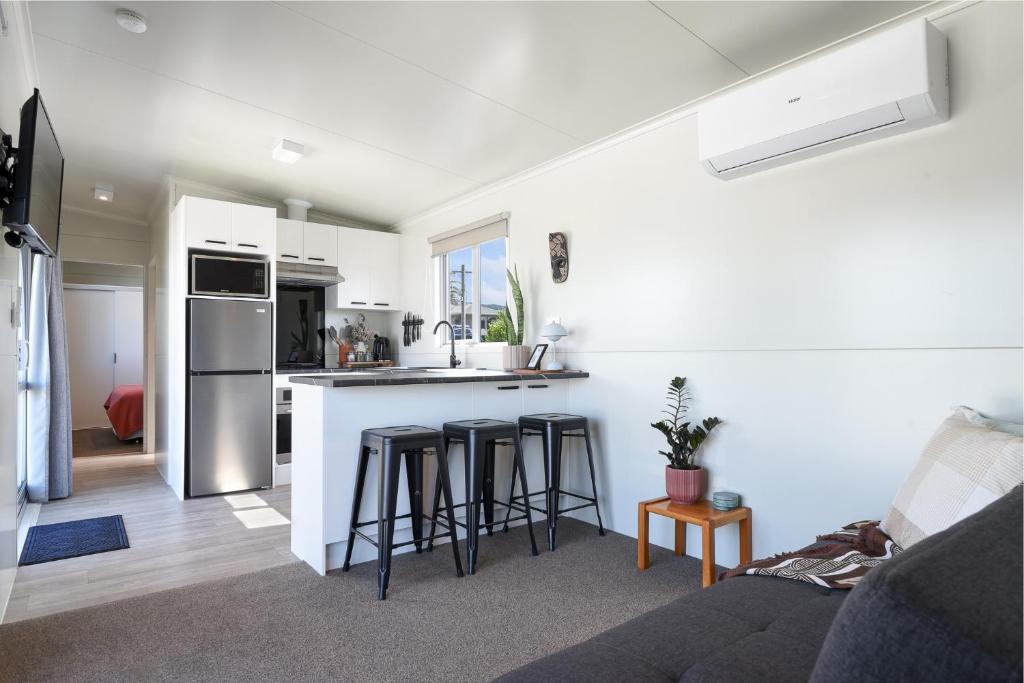a living room with a couch and a kitchen at Ngongotahā Getaway in Rotorua