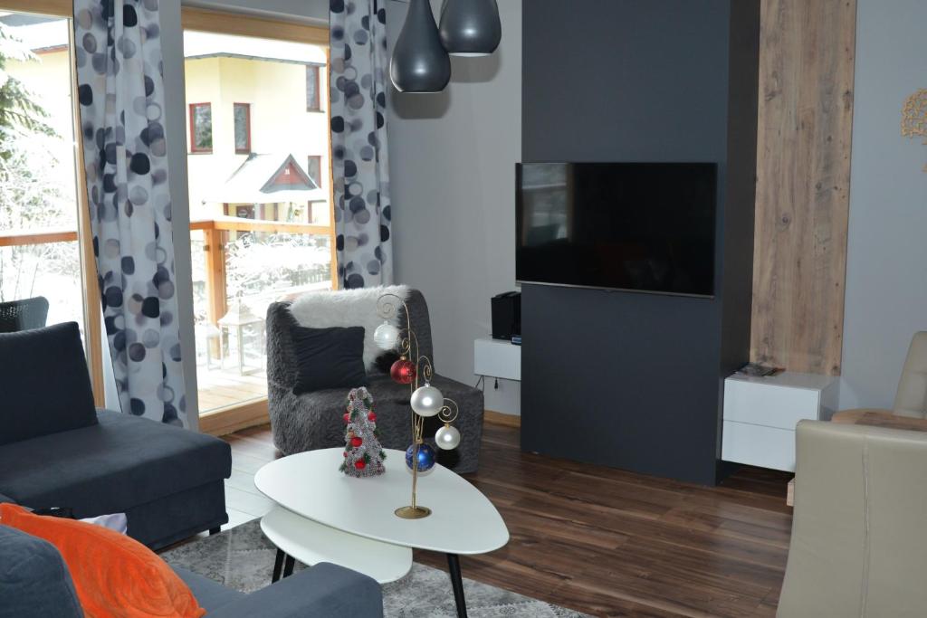 Televízia a/alebo spoločenská miestnosť v ubytovaní Apartament Ornak