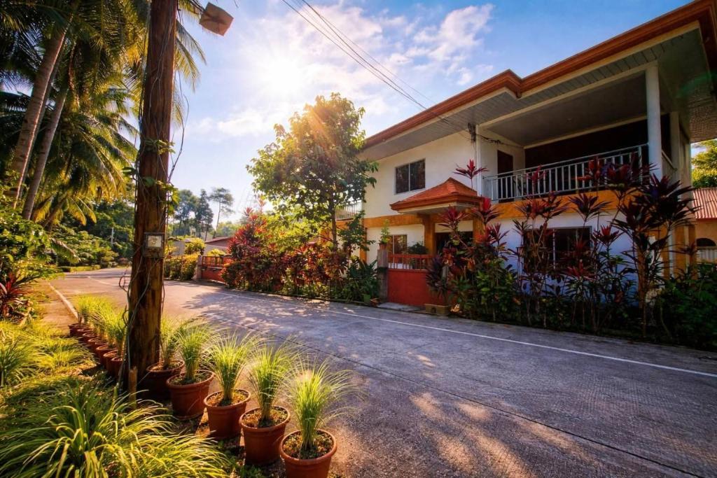 a street in front of a house with potted plants at Jenalfe Guest House in Camiguin